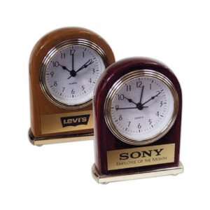Arch shaped wood finish clock with gold plate on the front.  