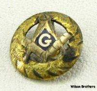 This pin features a wreath framing a square and compass emblem with a 